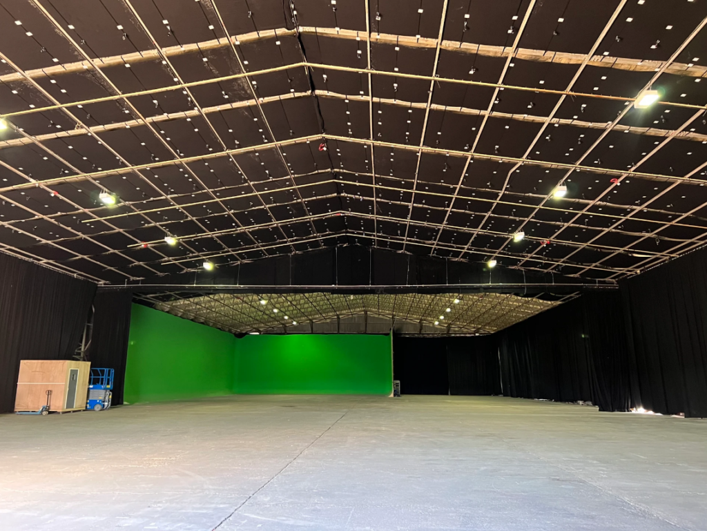 Inside the 32,000 sq ft Black Hangar sound stage with the green screen and lighting grid