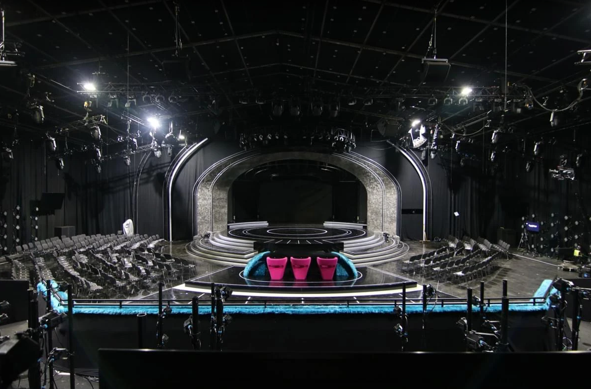 Stage and audience seating set up for an event inside the Black Hangar sound stage